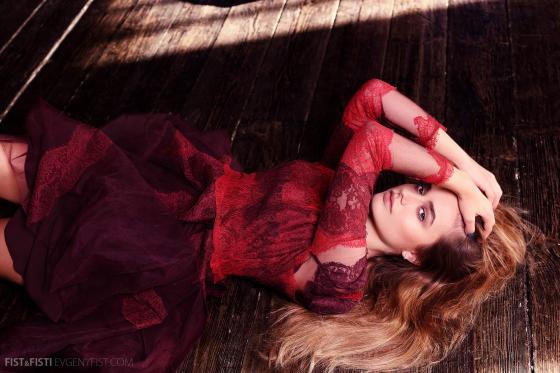 Фото девушка в красном кружевном платье лежит на деревянном полу