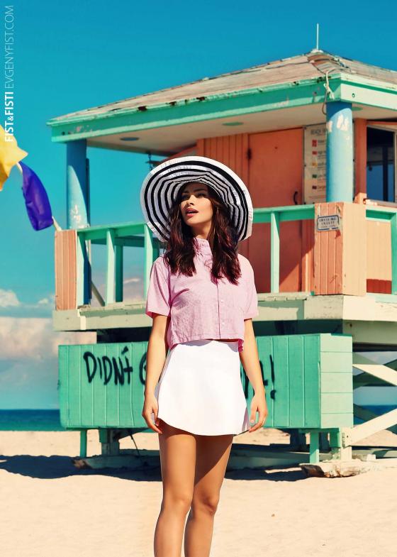 Фото на пляже девушка в шляпе на фоне спасательного домика