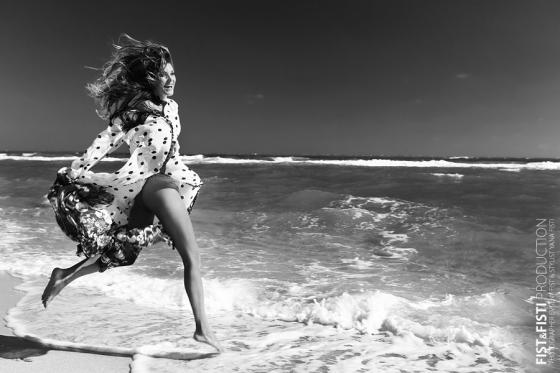 Черно-белая фотография девушка бежит в океан на фоне волн