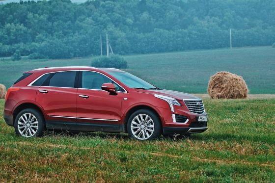 Красный Cadillac XT5 на фоне русского поля
