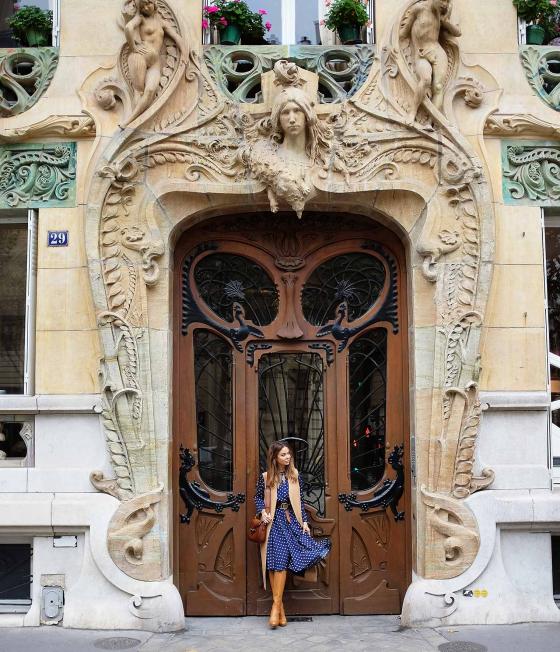 Яна Фисти на фоне расписного входа в здание в Париже